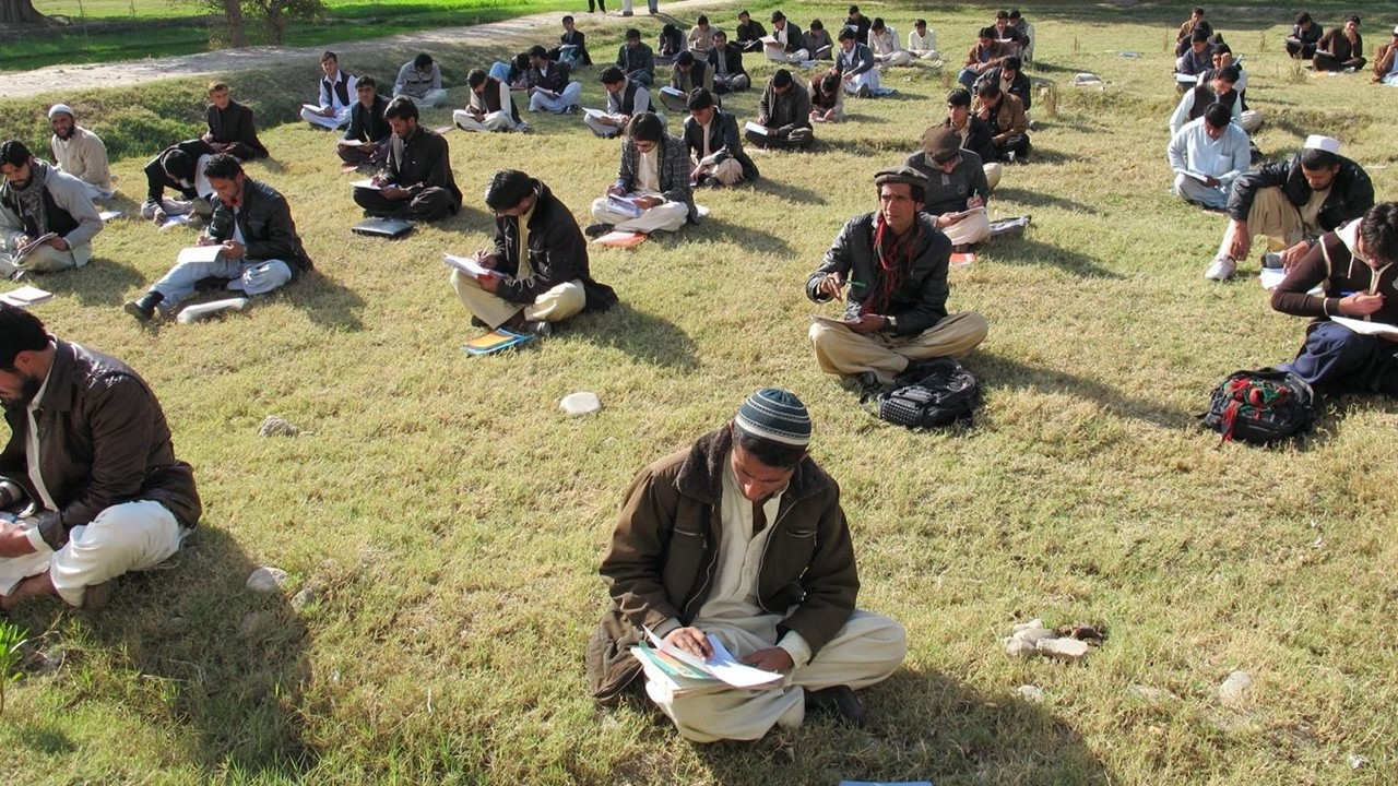 First-year students taking a test outside the classroom at Nangarhar University in Afghanistan (2011).